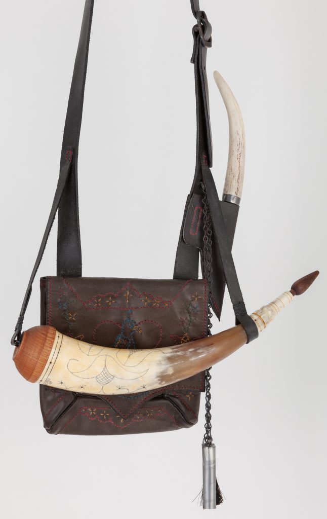 Bag # 52 with Horn #64 - Small fraktur embroidered shot pouch and an aged white powder horn with cherry base plug, antler tip, walnut stopper, and contemporary fraktur engraving with a white axis deer antler handled patch knife - outside view